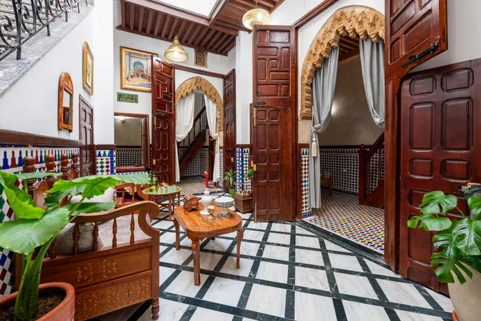 Le patio du Riad Jasmine, portes en bois sculpté, arche et sol en marbre noir et blanc
