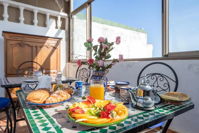 Le petit-déjeuner servi sur la terrasse, fruits, viennoiseries et thé